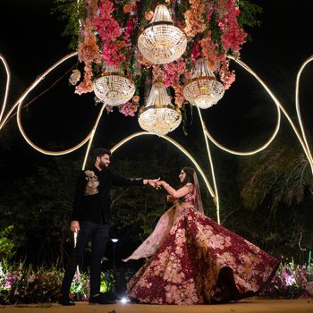 Swathed in rich hues and lit up by whimsical neon elements, this couple’s wedding reception decor was regal and modern