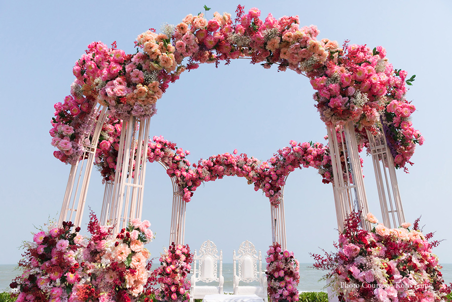 Beachside mandap in pink and red floral decor at Thailand