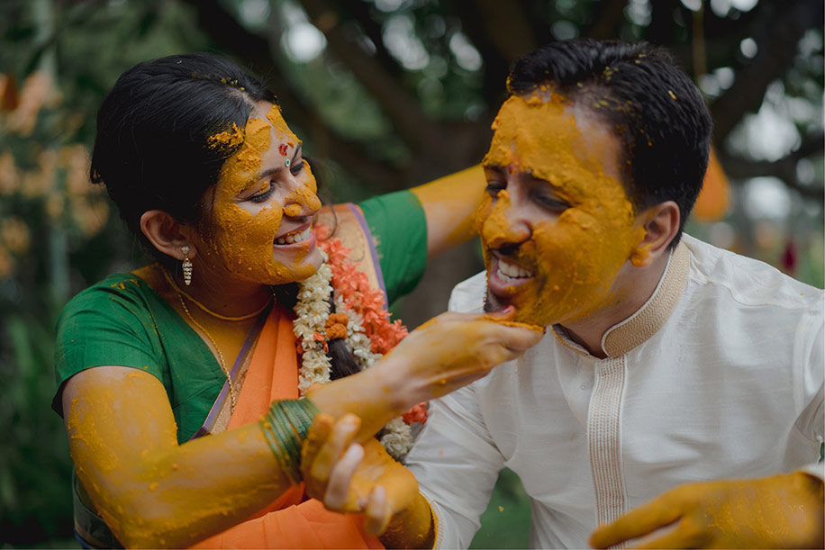 Bride in yellow sari and groom in white kurta for lockdown haldi celebration