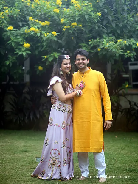 bride wearing purple lehenga  and groom wearing yellow kurta for haldi