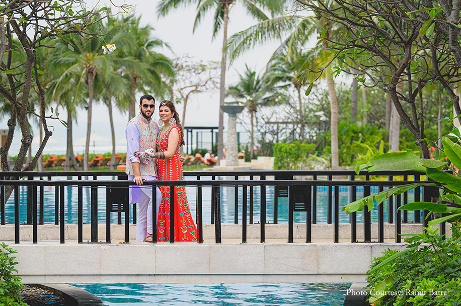 Bride wearing embroidered orange gown from Papa Don’t Preach by Shubhika with Outhouse jewelry and groom wearing a lavender kurta with a dapper multi colored Bandi jacket for Mehndi at Sheraton Hua Hin