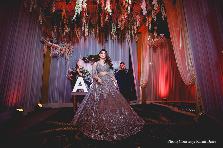 The groom wearing a navy velvet bandhgala while the bride shimmered in a silver embellished lehenga for the reception