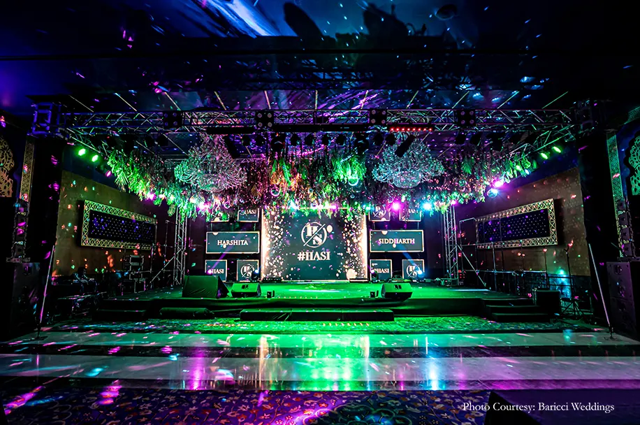 Neon hues, rich foliage canopies hung with shiny disco balls, cold pyros and chandeliers decor for the sangeet