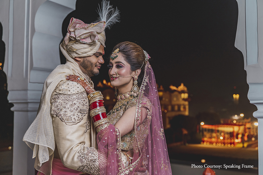 Bride pink and white shimmery Rimple and Harpreet Narula lehenga and groom in off-white and gold sherwani by Sulakshana Monga for the wedding at Jaipur