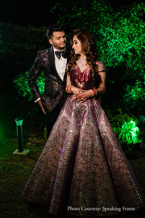 Bride in dark purple, metallic Amit Aggarwal gown and groom in dark floral tuxedo by Qbik at Reception