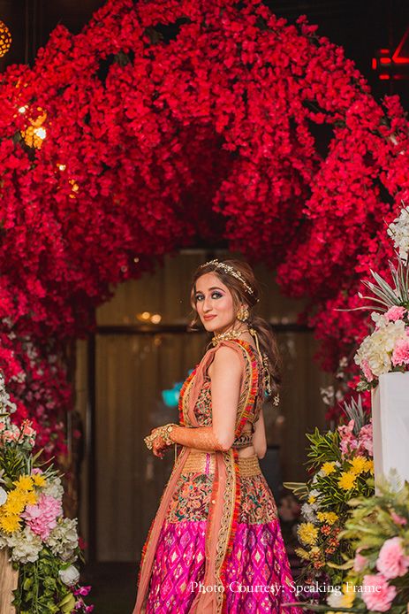 Bride wearing pink one-shoulder lehenga with jewelry by Qbik