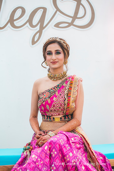 Bride wearing pink one-shoulder lehenga with jewelry by Qbik