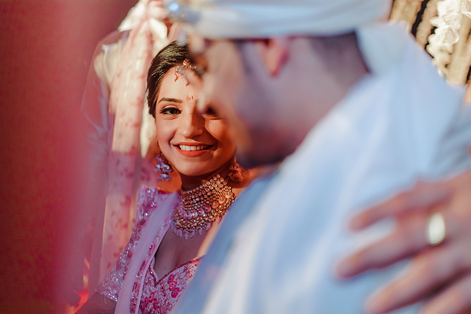 Bride wearing white and pink embroidered lehenga and groom wearing a white sequined sherwani and turban Bride wearing white and pink embroidered lehenga and groom wearing a white sequined sherwani and turban