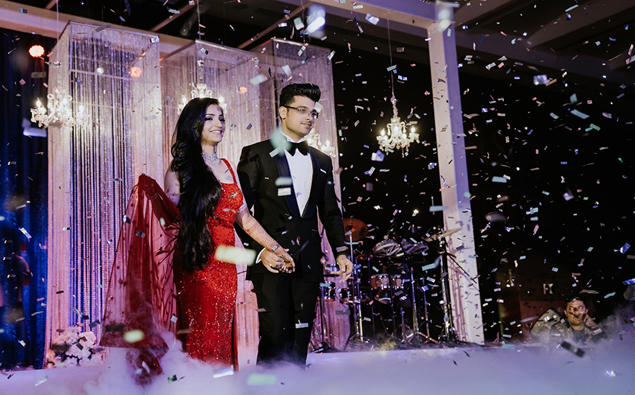 Bride in red gown and groom wearing black tuxedo for reception Bride in red gown and groom wearing black tuxedo for reception