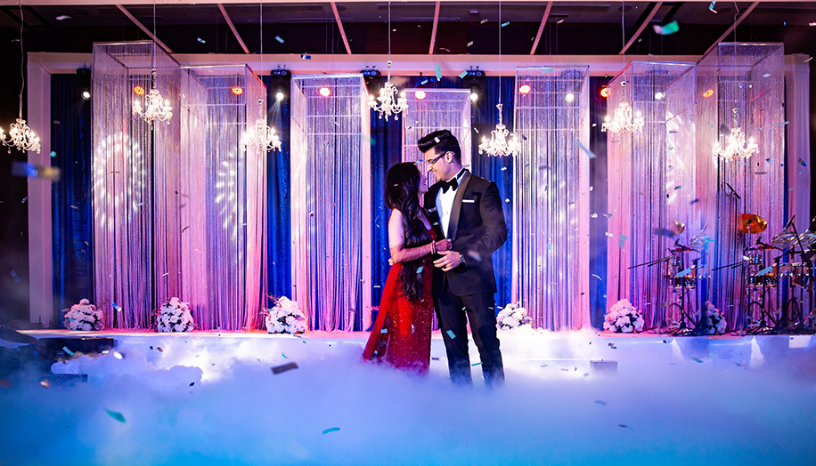 Bride in red gown and groom wearing black tuxedo for reception