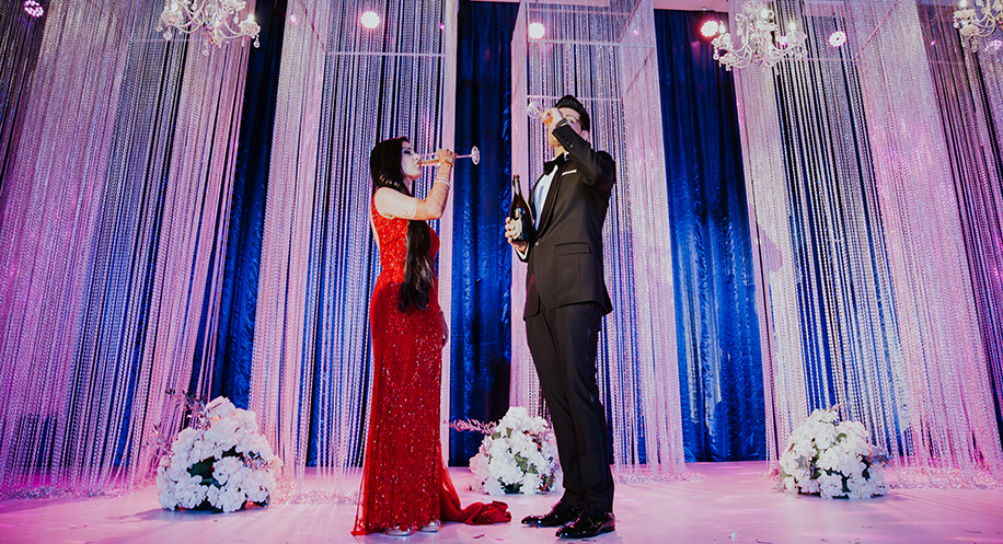 Bride in red gown and groom wearing black tuxedo for reception Bride in red gown and groom wearing black tuxedo for reception