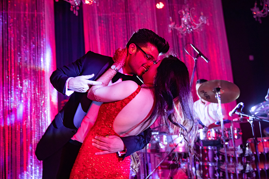 Bride in red gown and groom wearing black tuxedo for reception Bride in red gown and groom wearing black tuxedo for reception
