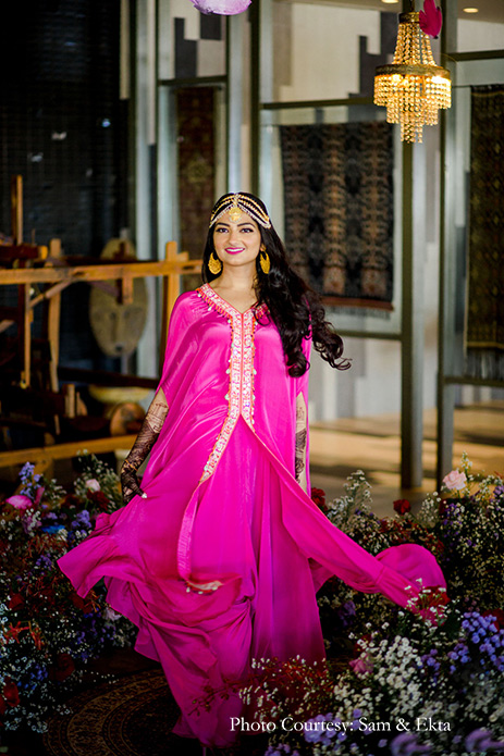 Bride wearing pink dress by Arpita Mehta and gold hair accessories for the mehendi at Bali