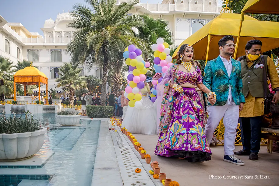 Bride in purple embroidery lehenga and groom in Blue jacket for the pool party