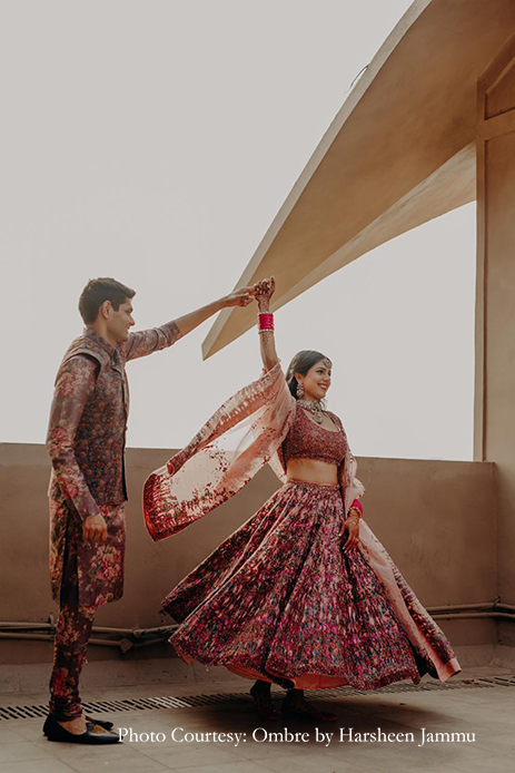 Bride in multicolored lehenga and groom in multi-color sherwani