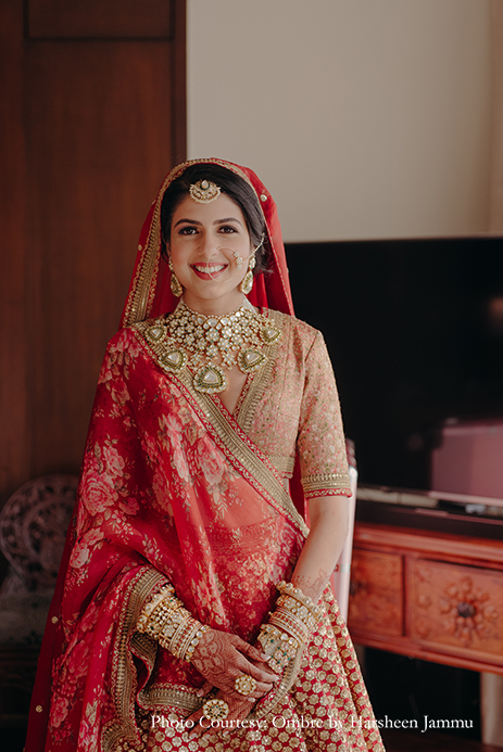 bride in red Sabyasachi lehenga and kundan jewelry