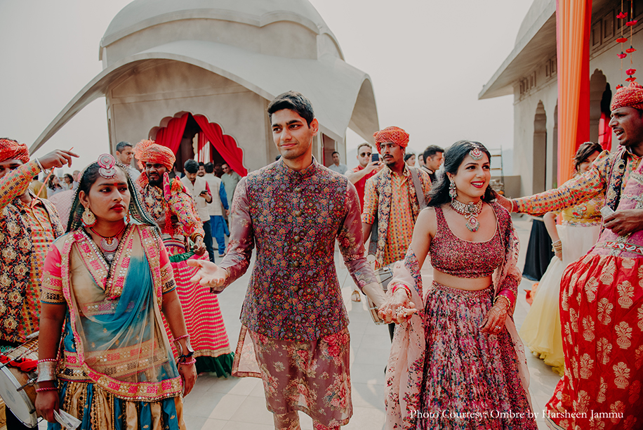Bride in multicolored lehenga and groom in multi-color sherwani