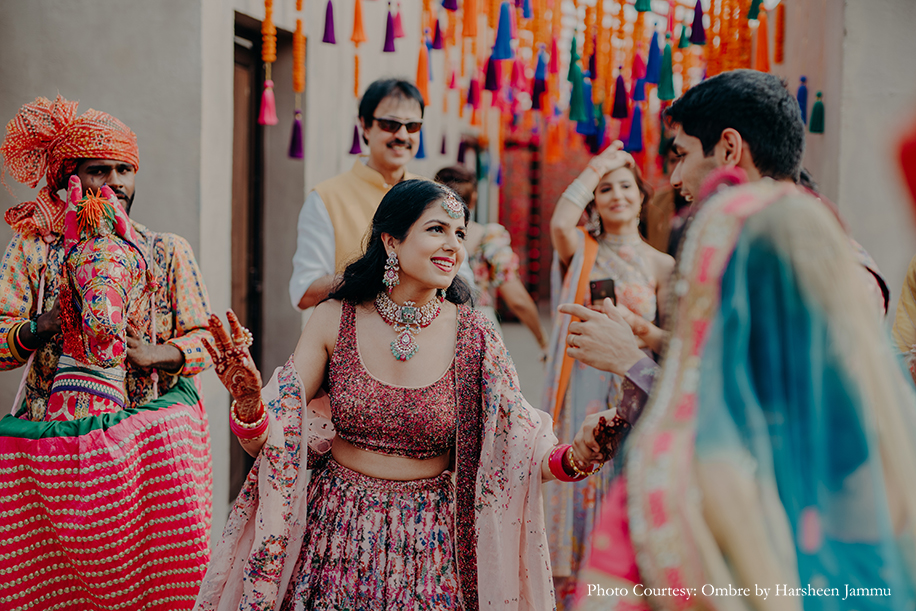 Bride in multicolored lehenga and groom in multi-color sherwani