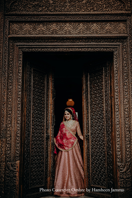 bride in red Sabyasachi lehenga and kundan jewelry