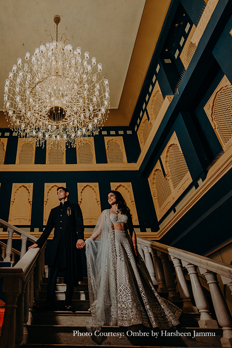 bride in silver embroidery sangeet lehenga and groom in black velvet bandhgala and black trousers