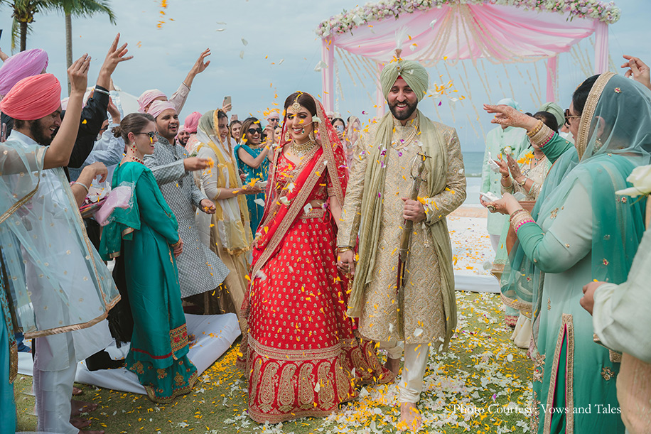 bride in red lehenga and groom in off white sherwani paired with a sage green turban for anand karaj at thailand
