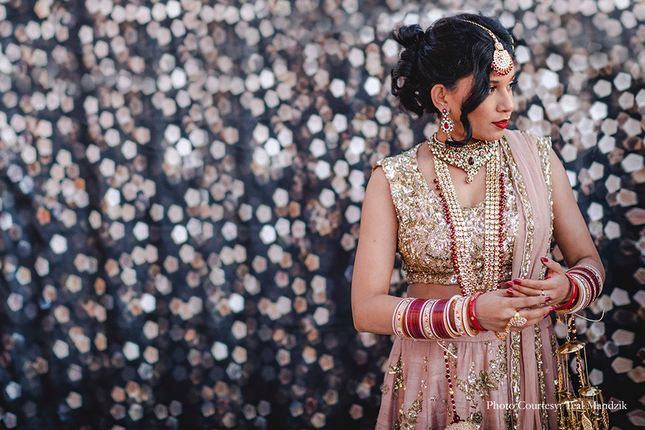 Bride wearing champagne pink lehenga by Astha Narang for the wedding