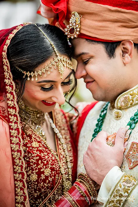 Bride wearing red lehenga and groom in cearm sherwani and red dupatta and safa for the wedding