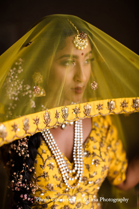 Bride wearing mustard yellow lehenga and customized kundan jewelry for the wedding at USA