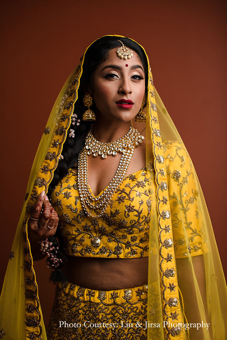 Bride wearing mustard yellow lehenga and customized kundan jewelry for wedding at USA