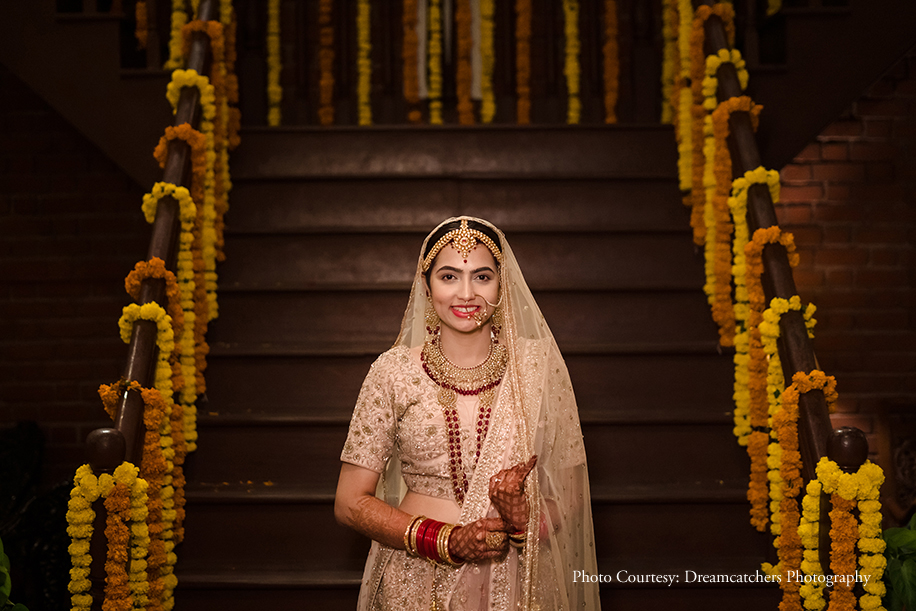 Bride wearing pink lehenga by Roopkala with Tanishq, Kushals jewelry at Wedding and Reception