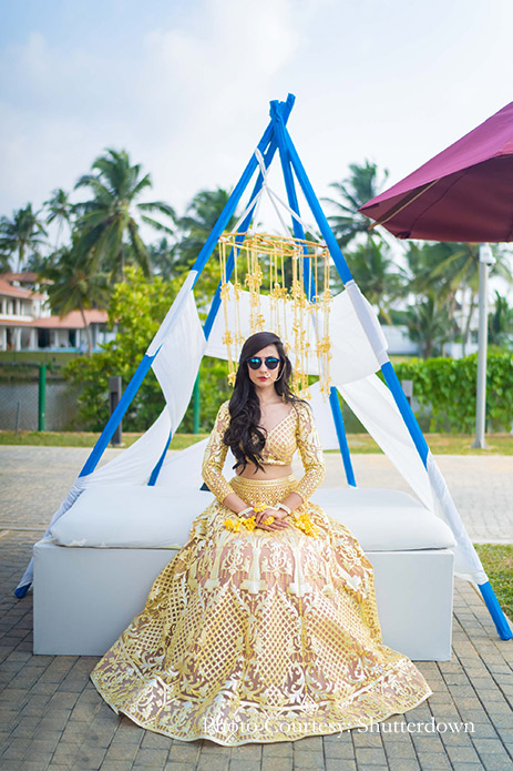 Bride wearing lemon Falguni & Shane Peacock lehenga with floral jewelry at Mehndi