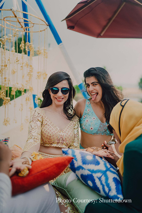 Bride wearing lemon Falguni & Shane Peacock lehenga with floral jewelry at Mehndi