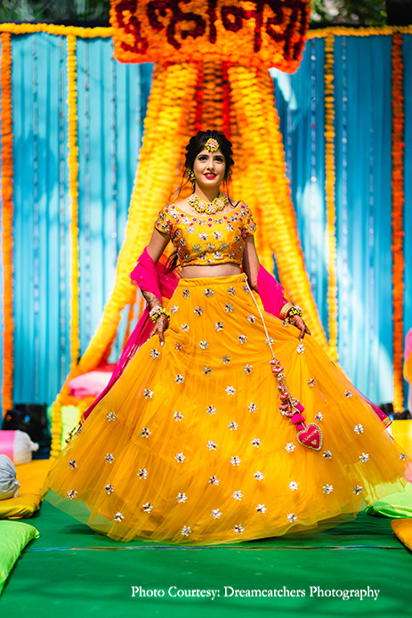 bride in vibrant yellow lehenga with a hot pink dupatta