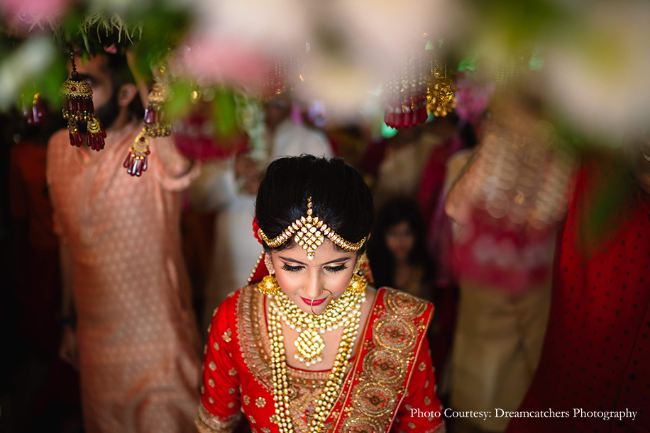 Bride entry in red lehenga by Kalki Fashions