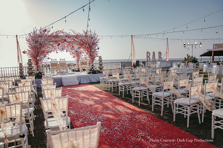 Beachside mandap in white, red, and pink floral decor at Goa