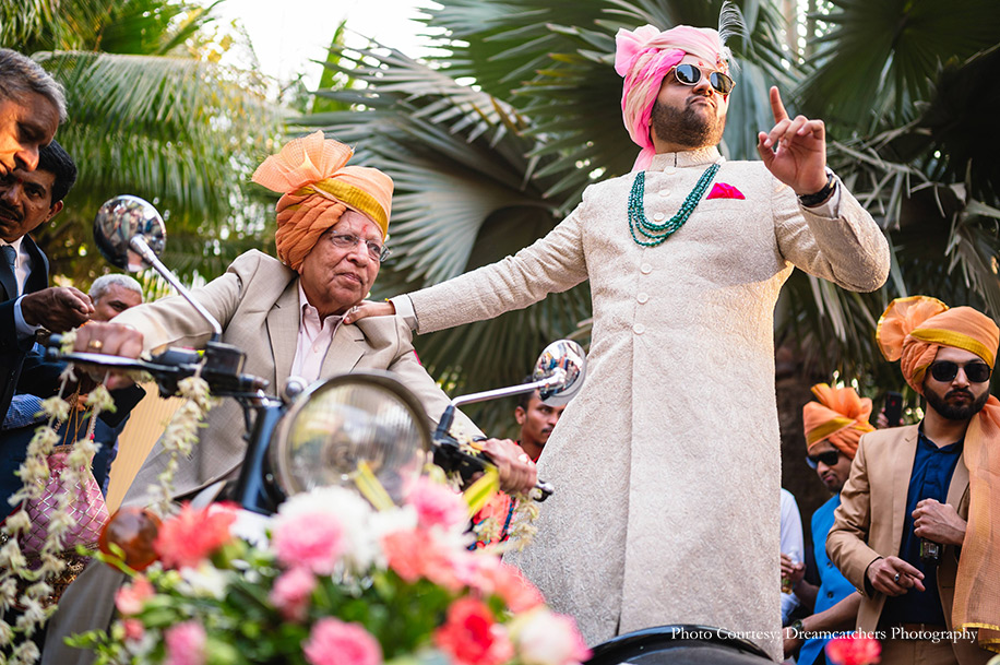 Groom in and groom wearing ivory sherwani with pink safa in baraat