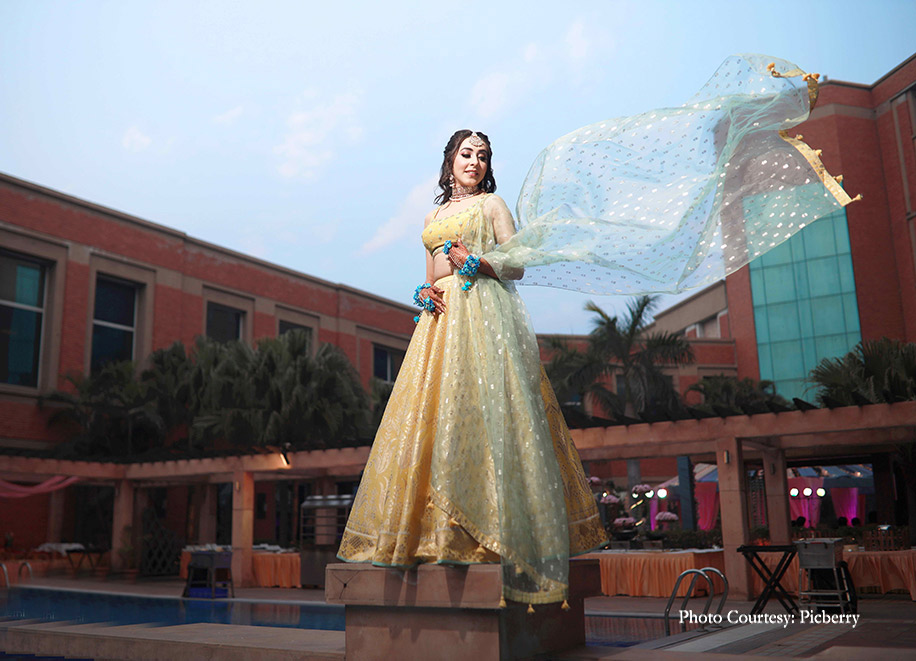 Bride in yellow and icy blue lehenga by Anita Dongre