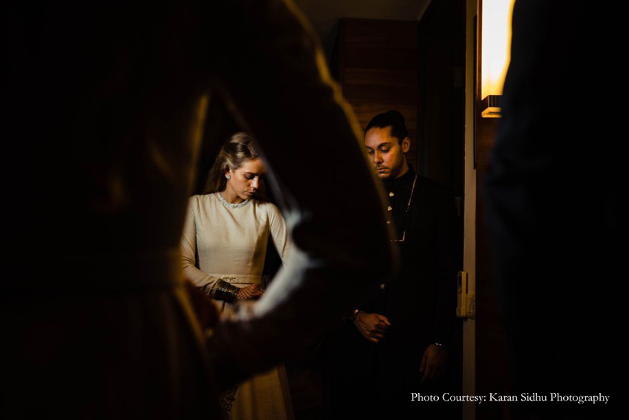 Bride in Cream Sabyasachi gown for cocktail and groom in black bandh gala