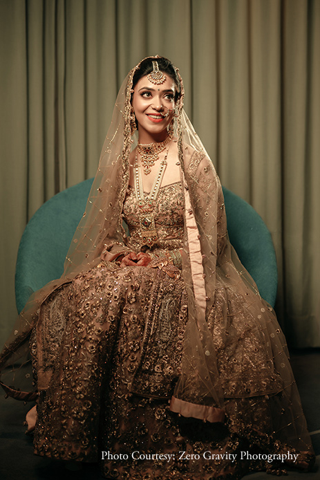 Bride wearing gold and cream Jiya by Veer Design Studio lehenga with Tribhovandas Bhimji Zaveri jewelry at Wedding