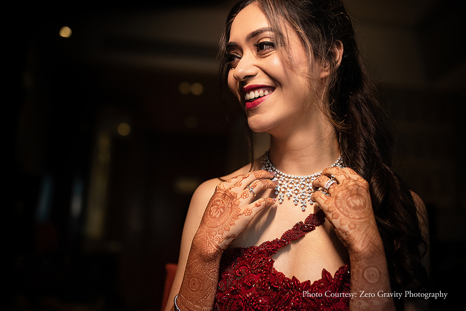 Bride wearing crimson gown by Sonaakshi Raaj with Niral Desai jewelry at Reception