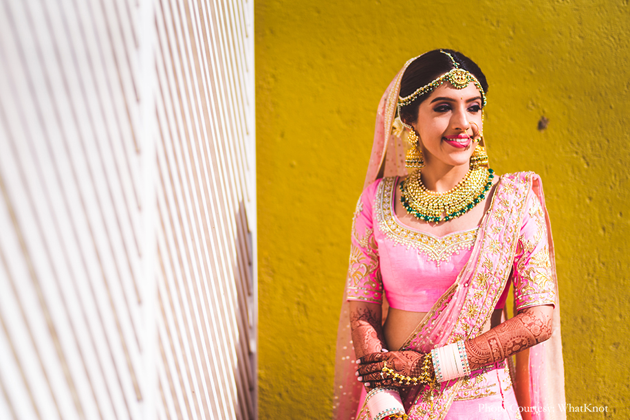 Bride wearing onion pink lehenga by Neeta Lulla with gold motifs, pearls, and sequins work