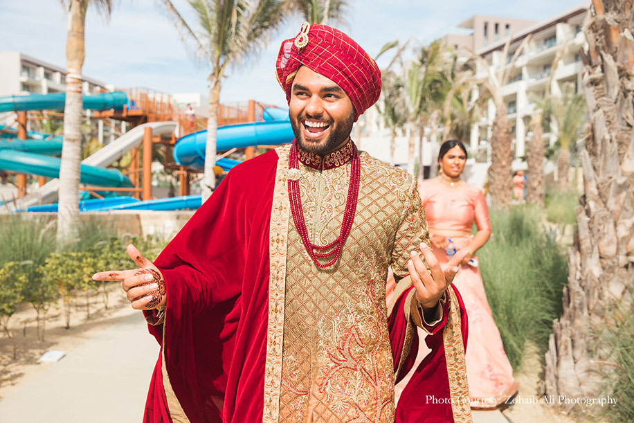 Groom wearing red and gold sherwani for wedding