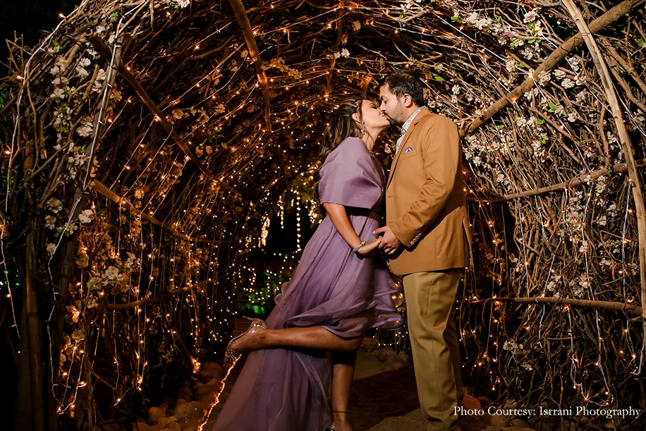 Bride wearing purple wrapped gown and groom wearing brown three-piece for the cocktail party