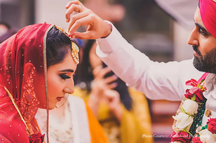 red safa and bride wearing red lehenga for the sikh wedding