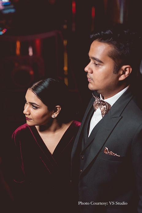 Bride wearing merlot velvet gown and groom wearing three-piece suit for cocktail