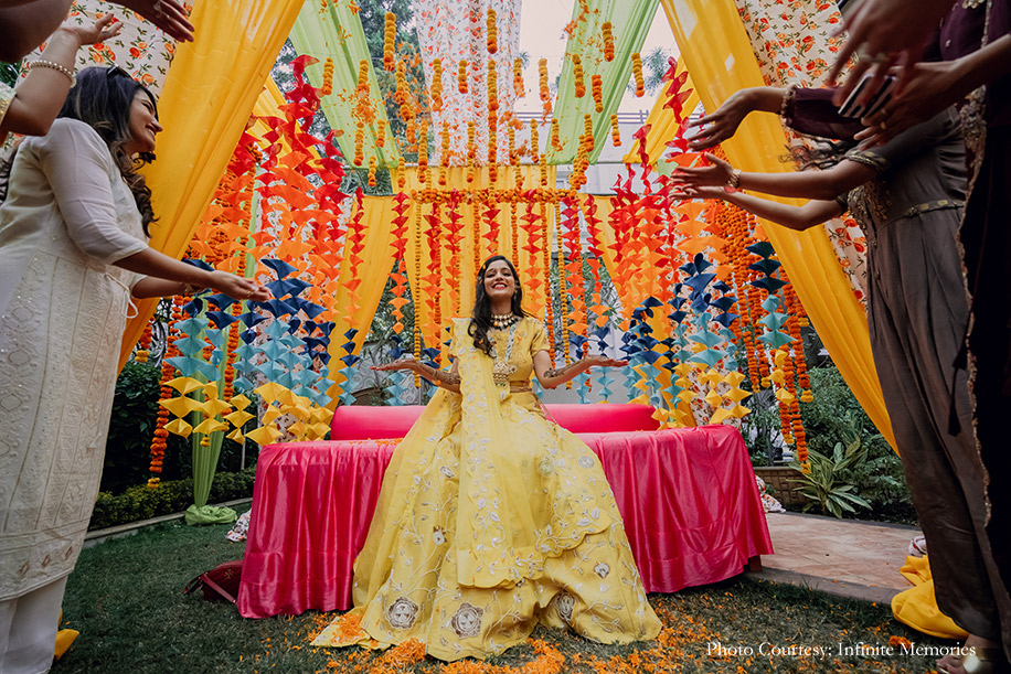Bride in yello embroidered lehenga for her mehndi with colorful Mehndi decoration