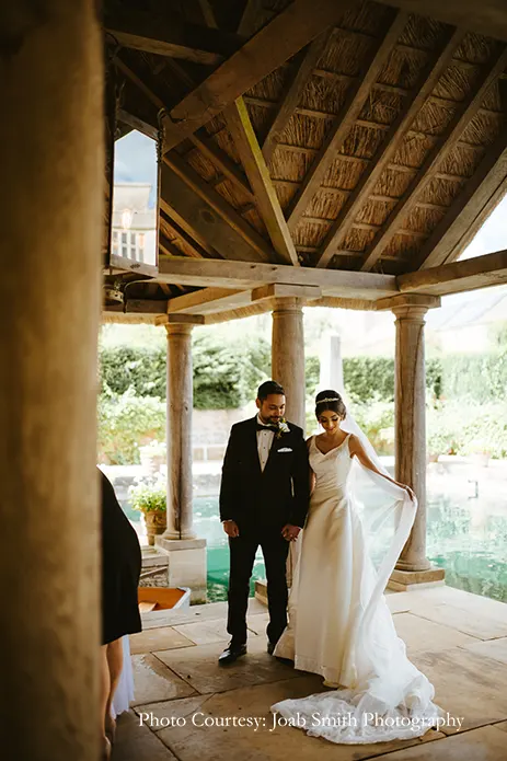 Bride in white gown and groom in black tuxedo for the white wedding