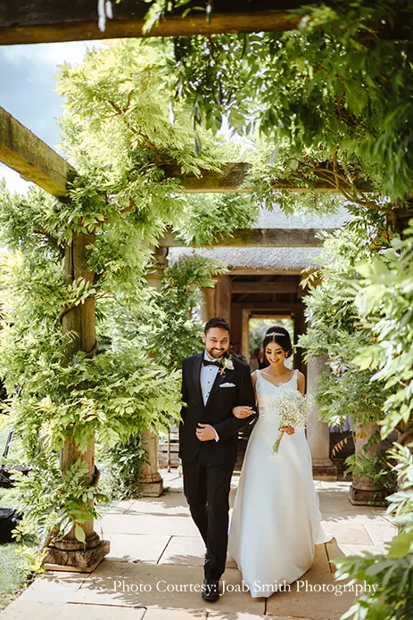 Bride in white gown and groom in black tuxedo for the white wedding