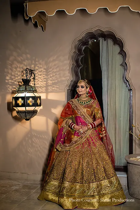 Bride in a rich gilded lehenga by Rimple and Harpreet Narula for her wedding
