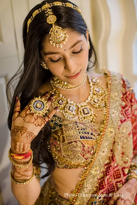 Bride in Gold multi-colored lehenga by Rimple and Harpreet Narula with Red Bandni dupatta and Kundan jewelry